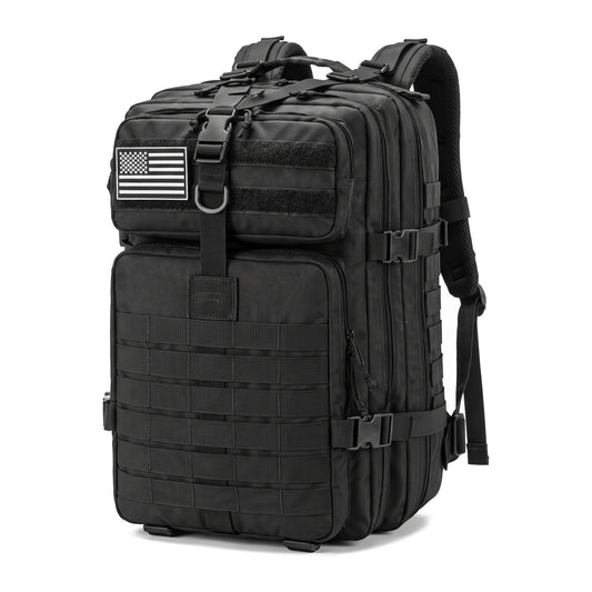 Mochila táctica negra con cintas MOLLE, hebillas laterales y parche de bandera, vista de frente en fondo blanco