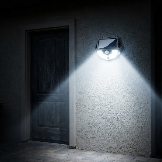 Reflector solar con sensor de movimiento encendido en la pared junto a una puerta, iluminando el patio de noche